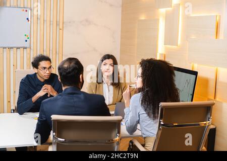 Working hard to win. Four young colleagues discussing documents for a business presentation while working in the creative office. Business concept Stock Photo
