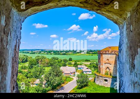 The view through the wide window of Medzhybizh Castle's tower on the side tower and surrounding fields and houses of the village, Ukraine Stock Photo