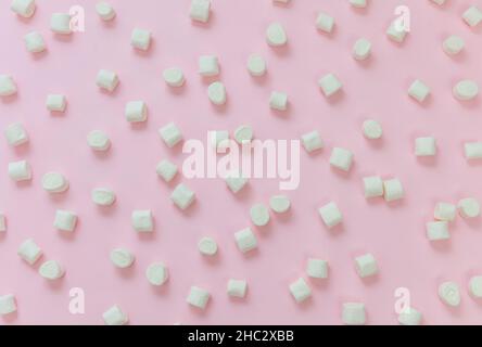 Marshmallows on pastel pink background. White fluffy mini dessert, sweet pattern, kids birthday party snack Stock Photo