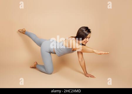Beautiful sporty fit yogini woman practices yoga asana marjariasana - cat  pose gentle warm up for spine (also called cat-cow pose) isolated on white  - SuperStock