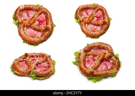 Pretzel with salami and lettuce isolated on a white background. Tasty snack. Stock Photo