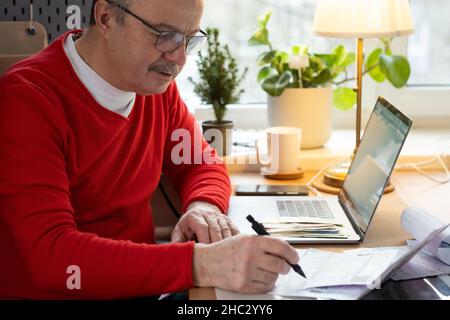 Senior man with eyeglasses counting money from retirement and control finance Stock Photo