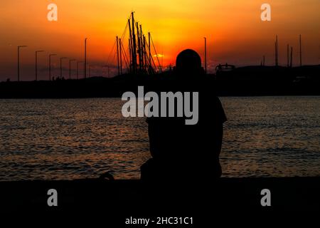 Man in silhouette looking at the distance at sunset Stock Photo