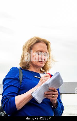 Female journalist taking notes Stock Photo