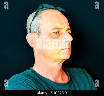 Creative portrait. Middle aged man with glasses. Portrait of mature man on black background. Copy space Stock Photo