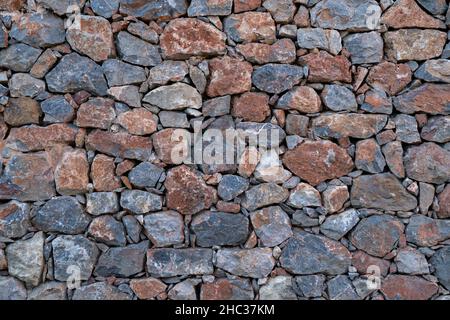 Textured background of masonry wall made of natural stones. Stock Photo