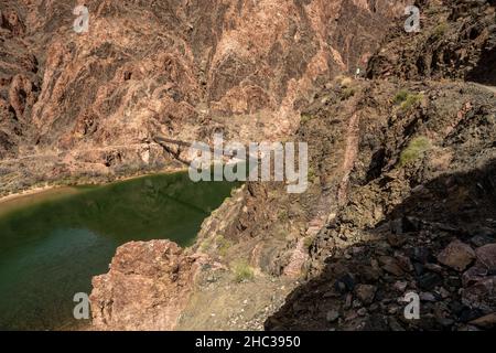 Hiker Looks Out Over The Black Bridge On The Colorado River in the Grand Canyon Stock Photo