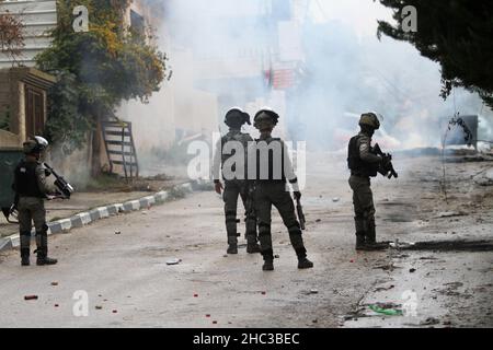 Nablus, Palestine. 23rd Dec, 2021. Israeli soldiers fire tear gas canisters at Palestinians protesters during the demonstration.Palestinians protested for the rebuilding of the Jewish settlement of Homesh, which was evacuated in 2007. Israeli settlers destroyed Palestinian villages, homes and cars during the protest in the village of Burqa. (Photo by Nasser Ishtayeh/SOPA Images/Sipa USA) Credit: Sipa USA/Alamy Live News Stock Photo