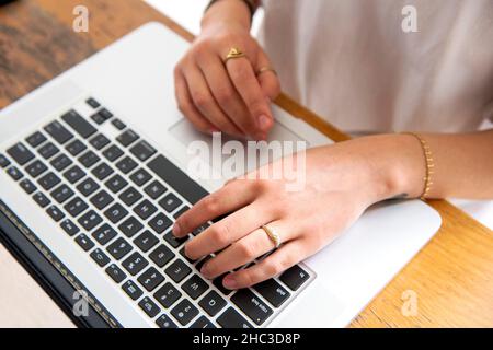 Hands of woman using laptop at home Stock Photo