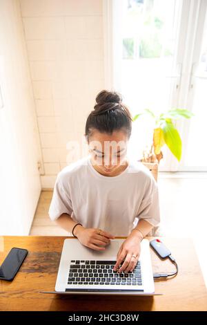 Young woman using laptop at home Stock Photo