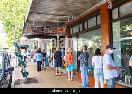 Christmas Eve in Sydney 2021, customers queue to collect meat and turkeys from the local butcher and buy bread from the bakery, masks for covid virus Stock Photo