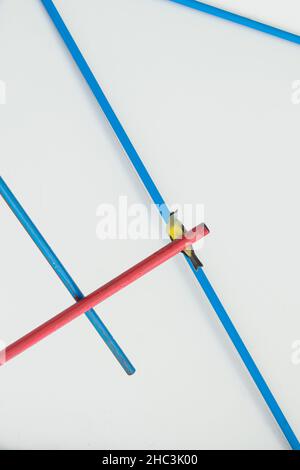 View from below of a little yellow bird on a red tube in background of a blue dome's  metal structure Stock Photo