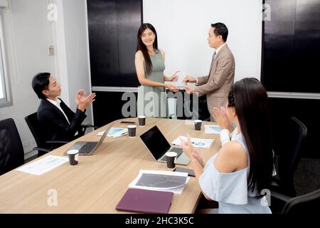 Young asian businesswoman receiving award with executive or manager for achievement in the office, employee proud reward and encourage in ceremony, gr Stock Photo