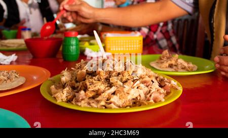 man making salsa to his carnitas tacos traditional Mexican from Michocan. High quality photo Stock Photo