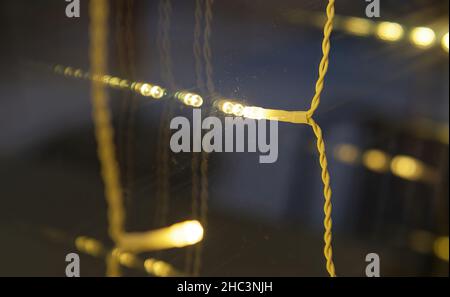 Selective focus picture of a small Christmas decoration led light hanging on a window Stock Photo