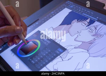An artist's hand drawing a manga on her digital tablet from home. Caserta, Italy, December 18th 2021. Stock Photo