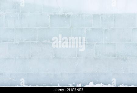 The textured surface of a translucent large ice wall made of large bricks. Stock Photo