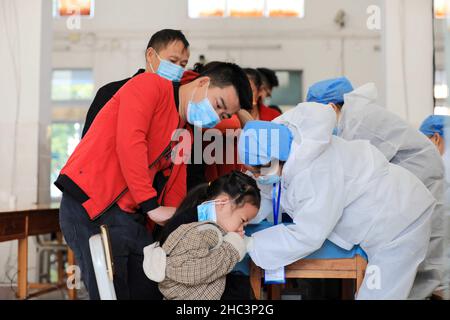 LIUZHOU, CHINA - DECEMBER 12, 2021 - Medical workers administer 'booster needle' to children at a centralized COVID-19 vaccination site in Liuzhou, Gu Stock Photo