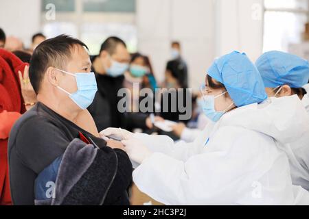 LIUZHOU, CHINA - DECEMBER 12, 2021 - Medical workers administer 'booster needle' at a centralized vaccination site for COVID-19 vaccine in Liuzhou, Gu Stock Photo