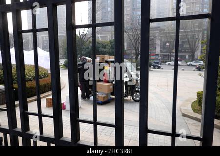 XI'AN, CHINA - DECEMBER 24, 2021 - An SF Express delivery vehicle stands at the gate of a gated community in Xi 'an, Shaanxi province, Dec 24, 2021. Stock Photo