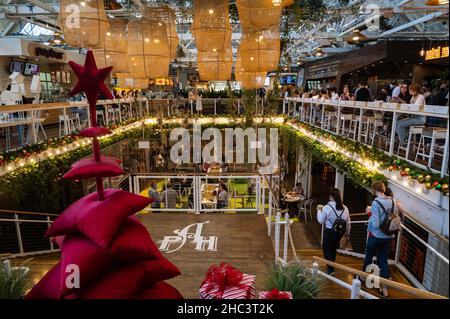 Photo of the upscale, trendy food court area with holiday decorations, local vendors and bars in a renovated, historic 1919 citrus-packing house. Stock Photo