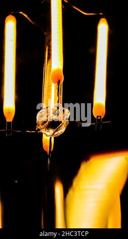 Vertical closeup of the modern chandelier on dark background. Stock Photo