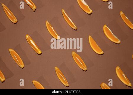 Colorful fruit pattern of fresh orange slices on brown background top view orange fruit pattern background Flat lay orange background cut Stock Photo