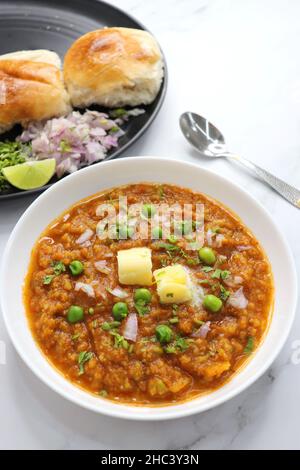 Indian Mumbai Street style Pav Bhaji, garnished with peas, raw onions, coriander, and Butter. Searved with pav. Stock Photo