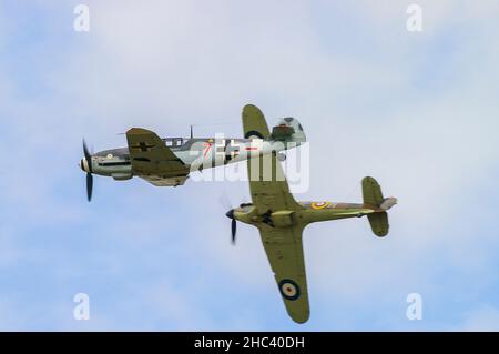 German Luftwaffe schemed Messerschmitt Bf-109 (Hispano HA-1112 Buchon) D-FWME, with RAF Hawker Hurricane R4118 Second World War fighter banking away Stock Photo