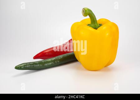 Set of fresh whole and sliced different colored sweet peppers (red, yellow, orange, green) isolated on white background. Top view Stock Photo