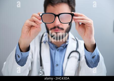 Unrecognizable doctor suggesting eyeglasses for a person with a vision problem. Stock Photo