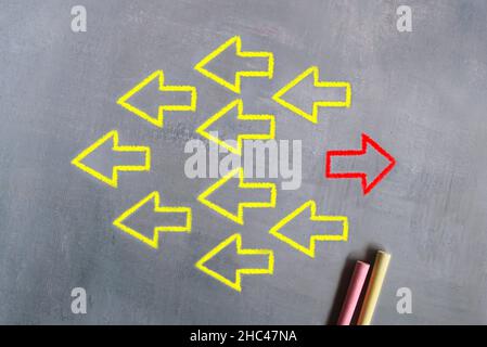 Unique, think different, individual and standing out from the crowd concept. Chalk and hand drawing image of arrow sign in opposite direction from oth Stock Photo