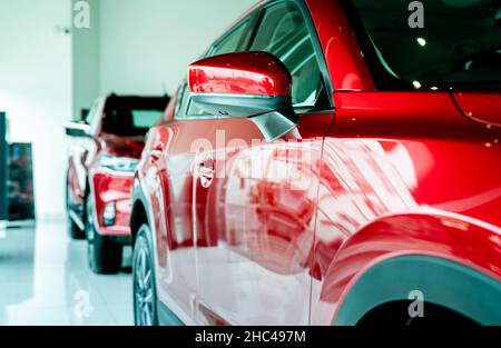 Selective focus red car parked in luxury showroom. Car dealership office. New car parked in modern showroom. Car for sale and rent business concept. Stock Photo