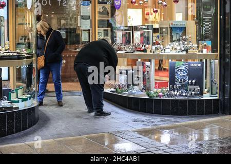 A Christmas shopper looking for last minute presents in Leeds City centre on Christmas Eve Stock Photo