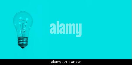 Light bulb on a blue background, long banner with space for text. Stock Photo