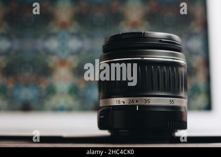 Close-up of a photo lens with a bokeh background on the table. Stock Photo