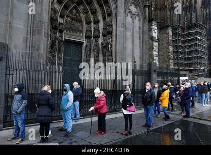 People queue to receive a dose of the Pfizer-BioNTech COVID-19 vaccine during a vaccination event in the Cologne Cathedral on Christmas Eve amid the coronavirus disease (COVID-19) pandemic in Cologne, Germany, December 24, 2021. REUTERS/Thilo Schmuelgen