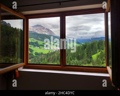 view through the window on the dolomites mountains and forest landscape Stock Photo