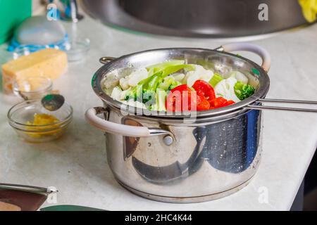 chopped boiled vegetables in colander in stainless steel cooking pot close-up Stock Photo