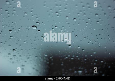A closeup of a glass covered in raindrops Stock Photo