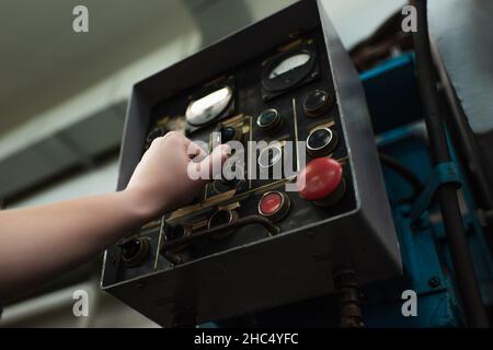 Low angle view of welder switching welding machine in factory Stock Photo