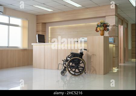 Empty modern wooden reception counter with monitor and wheelchair service in the hospital Stock Photo