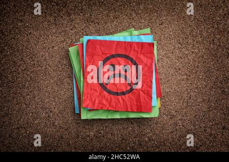 A stack of sticky notes with sad faces on them. Close up. Stock Photo