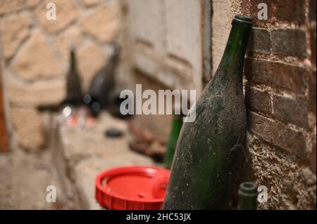 Closeup shot of an old, dirty bottle leaned on a wall Stock Photo