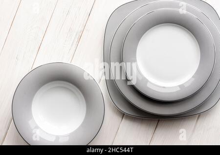 White round classical porcelain plates with a gray pattern stand on a white table Stock Photo