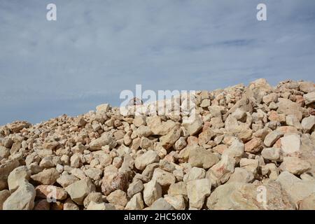 Photo of a large pile of stones at construction site, on the coastline of Mediterranean sea on calm day Stock Photo