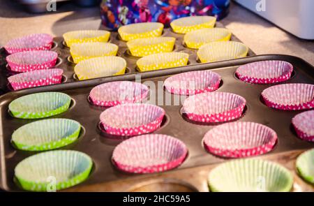 Empty cupcake cases in baking tins read to be filled. Stock Photo