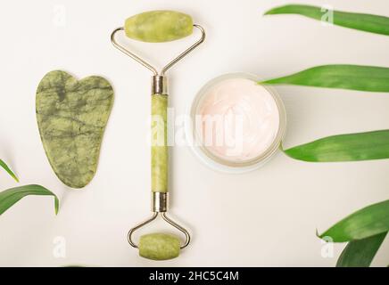 Face care and massage.Face roller with cream on white background Stock Photo