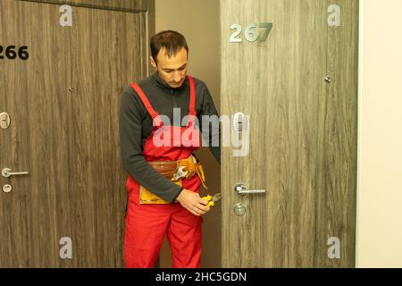 Male handyman carpenter at interior wood door lock installation Stock Photo