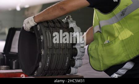 Calm workers controlling aircraft machine. Aircraft maintenance mechanic inspects plane chassis. Engine and chassis of the passenger airplane under he Stock Photo
